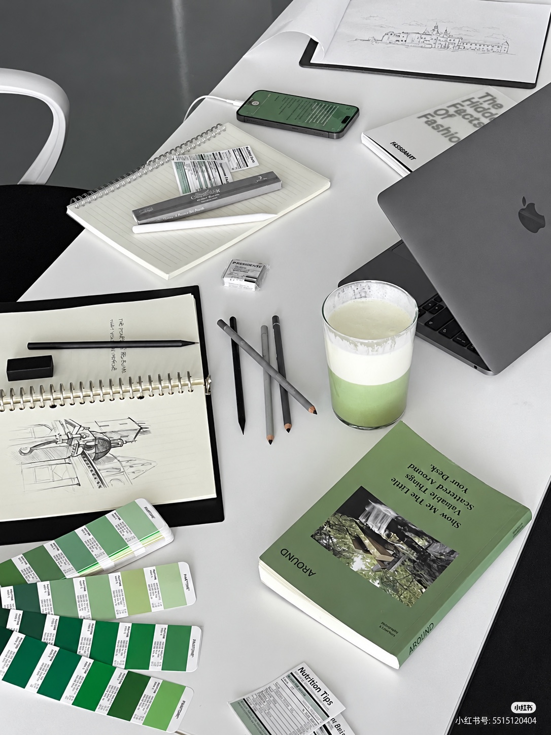 Design studio desk with sketchbooks and green colour swatches